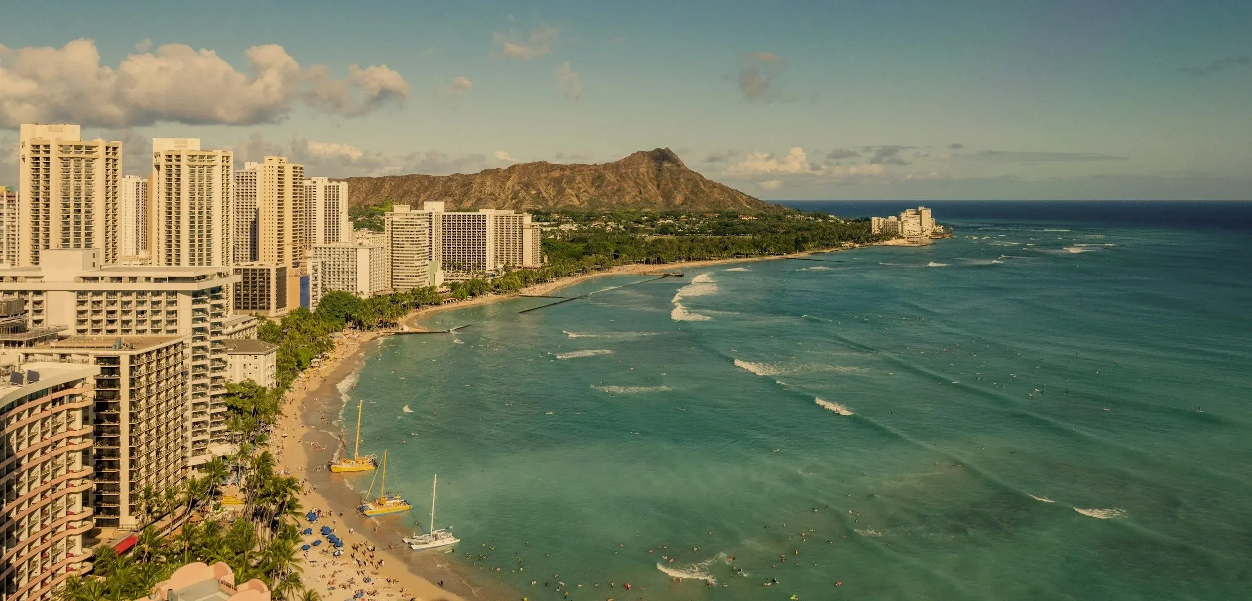 Waikīkī’s sweeping shoreline and Diamond Head, with sailing boats on the Pacific