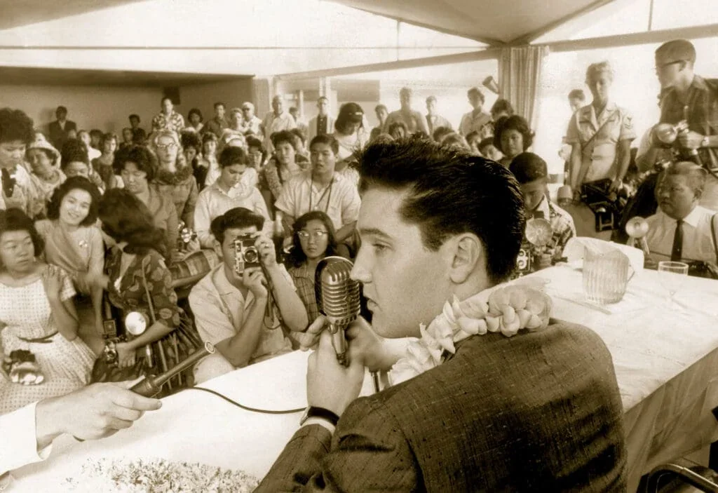 Elvis Presley answering questions at a crowded Hawaiian Village press conference in March 1961
