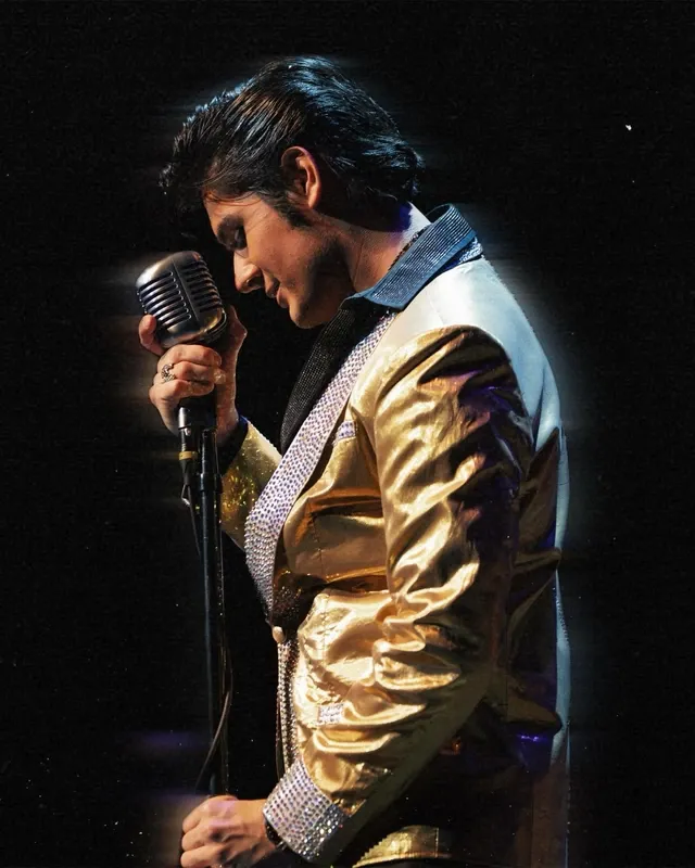 Moses Snow performing in a gold jacket with a vintage microphone